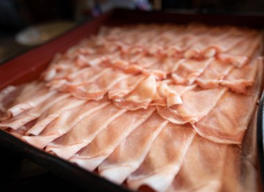 Japonca restoranındaki bir konteynırda domuzlar sırayla kayıyor. Yakından bakınca spor odakları bulanıklaşıyor.