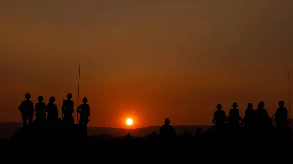 特殊部隊のシルエットグループ兵士たちが日没の背景に戦車に座り — ストック写真