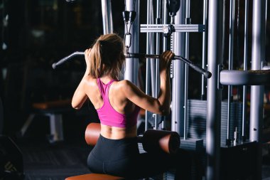 Spor salonunda spor yapan Asyalı bir kadın. Kas egzersizi yapıyor. Kollar ve omuzlara odaklanıyor. 