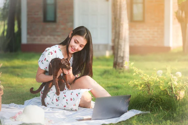 Bahçesinde kedisi olan serbest Asyalı kadınlar.,
