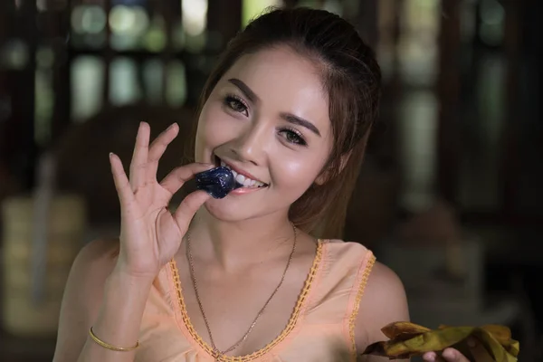 タイのモデルはタイの伝統的な茶色のドレスを着てキャンディを食べる — ストック写真