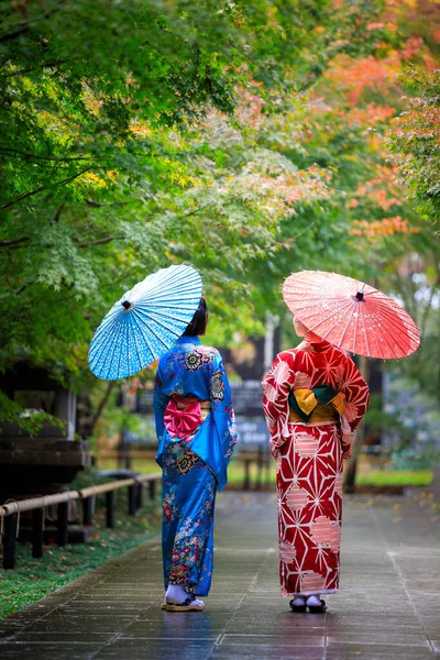 Дві Молоді Азійки Одягнені Синє Червоне Кімоно Парасолькою Тримаючи Руку — стокове фото