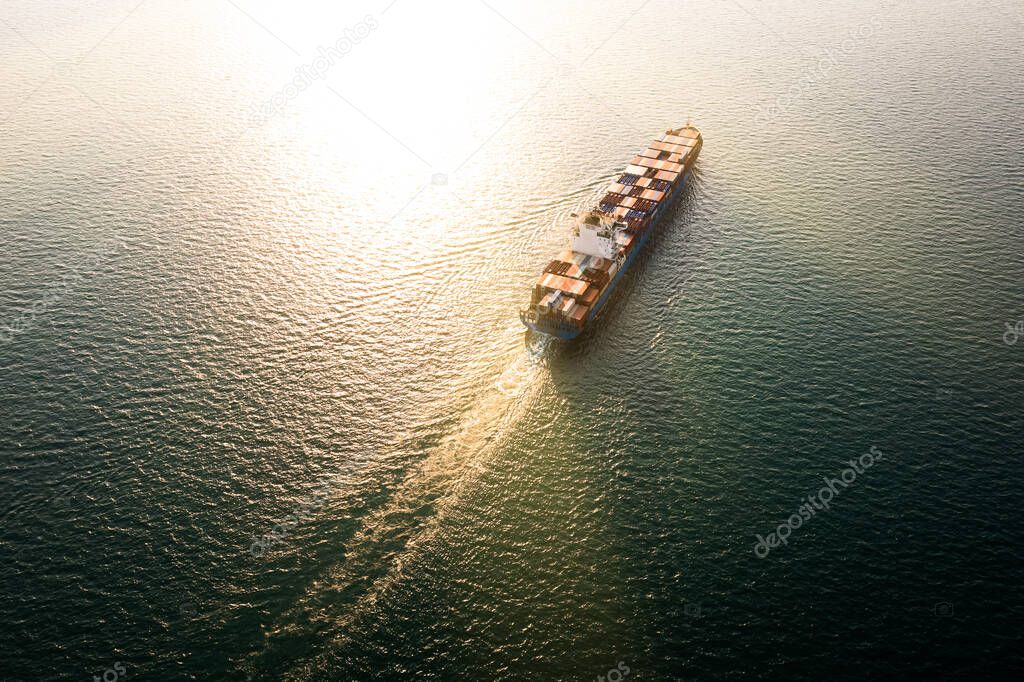 Aerial view container cargo ship carrying commercial container import export business delivery service commerce logistic and transportation international by container ship in sea over sunlight background at evening 