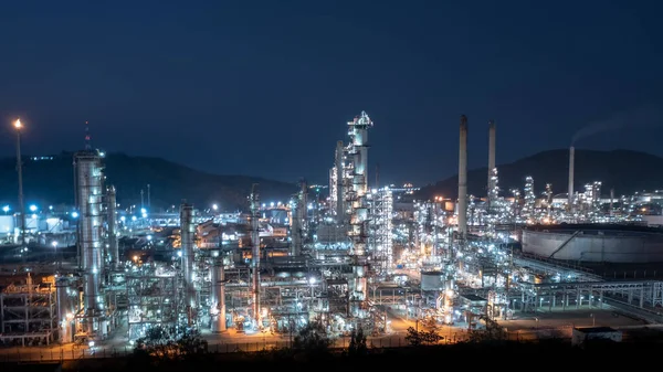 Aerial view of Chemical industry storage tank and oil refinery in Industrial Plant at night over lighting, Fuel and power generation, petrochemical factory industry zone, pullution and wasted energy concept,
