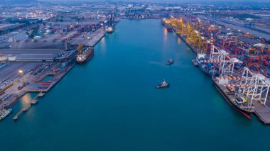 Konteyner gemisi terminali, konteynır gemisinin yükleme ve iskele vinci konteynır gemisiyle sanayi limanında, kargo nakliyesi ihracat lojistik taşımacılığı havaalanında alacakaranlıkta