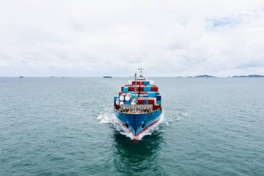 Konteynır kargo gemisi yeşil denizde son sürat yol alıyor. Uluslararası ya da dünya çapında ithalat mal ihracatı iş ve sanayi taşımacılığı ve deniz hizmetleri olarak İHA 'dan açık deniz hava görüntüsü, nakliye konsepti,
