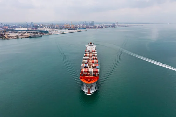 container ship sailing to transport goods in containers for import export internationally and worldwide, business services transportation by container ship open sea, aerial view photograph from drone, commercial dock background