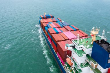 Kargo konteynırı ithalatı taşıyan konteyner gemisinin anten arka görüntüsü uluslararası ve dünya çapında ihracat, ticari ve endüstriyel mallar konteyner gemisiyle açık denizde lojistik taşımacılık, kargo konteynırı konsepti,