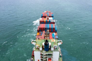 Kargo konteynırı ithalatı taşıyan konteyner gemisinin anten arka görüntüsü uluslararası ve dünya çapında ihracat, ticari ve endüstriyel mallar konteyner gemisiyle açık denizde lojistik taşımacılık, kargo konteynırı konsepti,