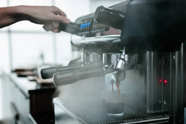 asian man bartender mixing and pouring coffee into cup from coffee machine at counter in small coffee shop business stratup concept, cinema film tone process