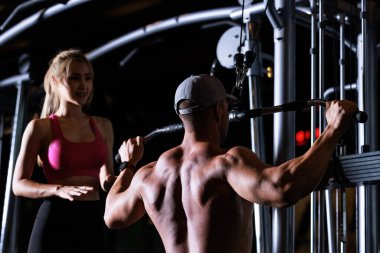 Fitness manand women working out in gym doing exercise for back dark tone process,
