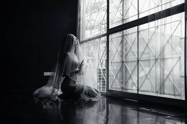 black and white young asian women model sitting poses naked by the window light only a thin curtain envelops her and dark background, lady sexy emotion of art concept,