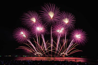 PATTAYA, CHONBURI, THAILAND, - NOVEMBER gecenin güzel ışıkları, renkli havai fişekler, Pattaya Uluslararası Havai fişek Festivali ve siluet grubu turistler oturup kumsaldaki yıllık havai fişek gösterisini izliyorlar..