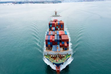 Konteynır gemisi, ticari ticaret lojistiği ve deniz aşırı taşımacılığıyla taşıdığı konteynır kutusu küresel iş teslimatı kargosuyla İHA 'dan dünya çapında hava manzaralı fotoğraf 