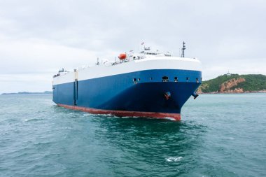 Yuvarlanan gemi yeni arabaları yüklüyor. Denizde yüzen otomotiv konteynır taşıyıcıları, iş hizmetleri ihracat ürünlerini okyanus taşımacılığında büyük bir Roll-on Roll gemisiyle ithal ediyorlar.