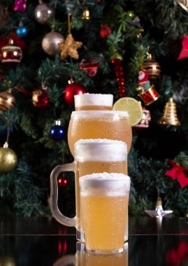 Noel temalı bir arka planda Amerikan bardağından Cozumel ve bira içmek.