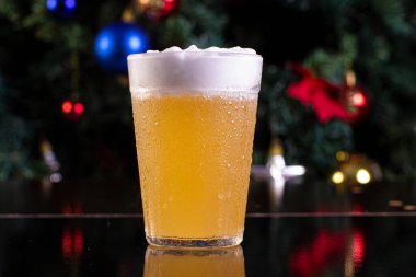 Noel temalı bir arka planda Amerikan bardağından Cozumel ve bira içmek.