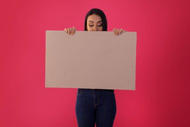 Gama, Distrito Federal, 16 Ekim 2021, genç kadın yüz ifadeleriyle reklam panolarını tutuyor..