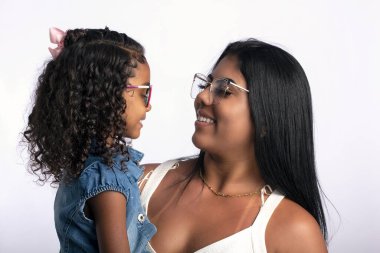 Fotoğraf stüdyosunda beyaz arka planda kızı olan genç bir anne.