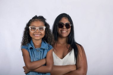 Fotoğraf stüdyosunda beyaz arka planda kızı olan genç bir anne.