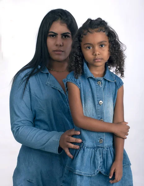 Fotoğraf stüdyosunda beyaz arka planda kızı olan genç bir anne.