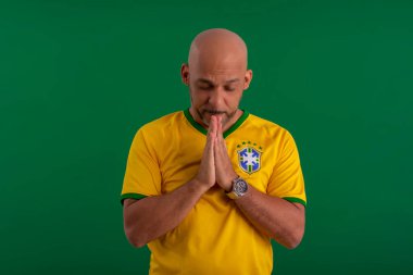 2022 kupasında Brezilya futbol takımını destekleyen Afro Brezilyalı bir adam, Brezilya bayrağı ve yüz ifadeleriyle.