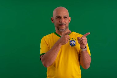 2022 kupasında Brezilya futbol takımını destekleyen Afro Brezilyalı bir adam, Brezilya bayrağı ve yüz ifadeleriyle.