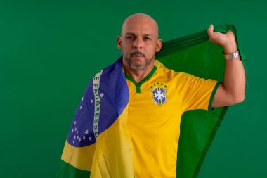 2022 kupasında Brezilya futbol takımını destekleyen Afro Brezilyalı bir adam, Brezilya bayrağı ve yüz ifadeleriyle.