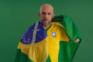 2022 kupasında Brezilya futbol takımını destekleyen Afro Brezilyalı bir adam, Brezilya bayrağı ve yüz ifadeleriyle.