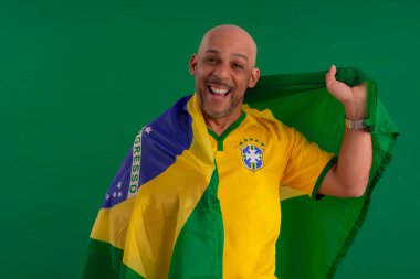 2022 kupasında Brezilya futbol takımını destekleyen Afro Brezilyalı bir adam, Brezilya bayrağı ve yüz ifadeleriyle.