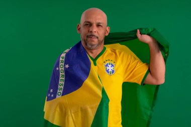 2022 kupasında Brezilya futbol takımını destekleyen Afro Brezilyalı bir adam, Brezilya bayrağı ve yüz ifadeleriyle.