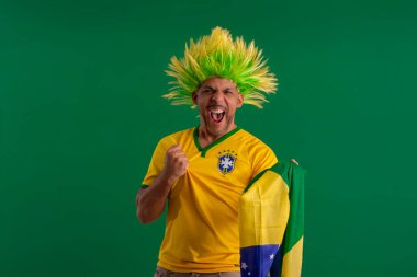 2022 kupasında Brezilya futbol takımını destekleyen Afro Brezilyalı bir adam, Brezilya bayrağı ve yüz ifadeleriyle.