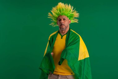 2022 kupasında Brezilya futbol takımını destekleyen Afro Brezilyalı bir adam, Brezilya bayrağı ve yüz ifadeleriyle.