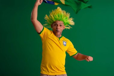 2022 kupasında Brezilya futbol takımını destekleyen Afro Brezilyalı bir adam, Brezilya bayrağı ve yüz ifadeleriyle.