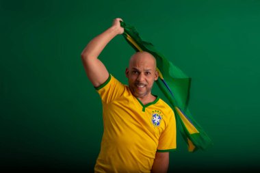 2022 kupasında Brezilya futbol takımını destekleyen Afro Brezilyalı bir adam, Brezilya bayrağı ve yüz ifadeleriyle.