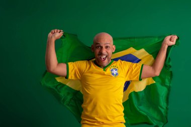 2022 kupasında Brezilya futbol takımını destekleyen Afro Brezilyalı bir adam, Brezilya bayrağı ve yüz ifadeleriyle.