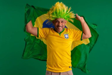 2022 kupasında Brezilya futbol takımını destekleyen Afro Brezilyalı bir adam, Brezilya bayrağı ve yüz ifadeleriyle.