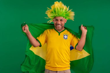 2022 kupasında Brezilya futbol takımını destekleyen Afro Brezilyalı bir adam, Brezilya bayrağı ve yüz ifadeleriyle.