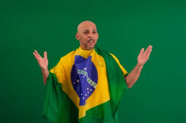 2022 kupasında Brezilya futbol takımını destekleyen Afro Brezilyalı bir adam, Brezilya bayrağı ve yüz ifadeleriyle.