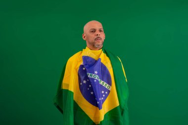 2022 kupasında Brezilya futbol takımını destekleyen Afro Brezilyalı bir adam, Brezilya bayrağı ve yüz ifadeleriyle.
