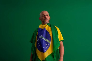 2022 kupasında Brezilya futbol takımını destekleyen Afro Brezilyalı bir adam, Brezilya bayrağı ve yüz ifadeleriyle.