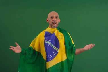 2022 kupasında Brezilya futbol takımını destekleyen Afro Brezilyalı bir adam, Brezilya bayrağı ve yüz ifadeleriyle.