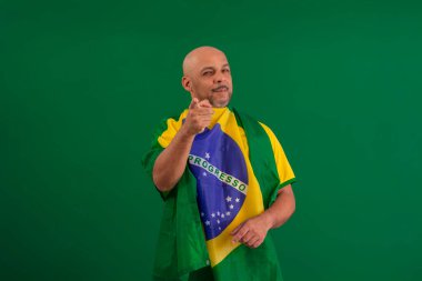 2022 kupasında Brezilya futbol takımını destekleyen Afro Brezilyalı bir adam, Brezilya bayrağı ve yüz ifadeleriyle.