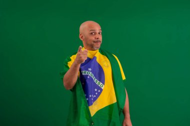 2022 kupasında Brezilya futbol takımını destekleyen Afro Brezilyalı bir adam, Brezilya bayrağı ve yüz ifadeleriyle.