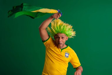 2022 kupasında Brezilya futbol takımını destekleyen Afro Brezilyalı bir adam, Brezilya bayrağı ve yüz ifadeleriyle.