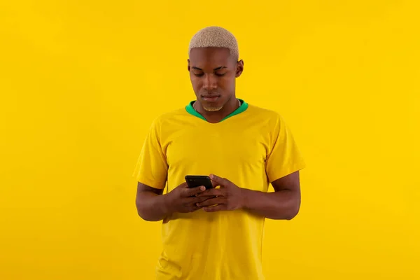 Stüdyo fotoğrafında Brezilya futbol takımı tişörtlü siyah tenli Brezilyalı adam.