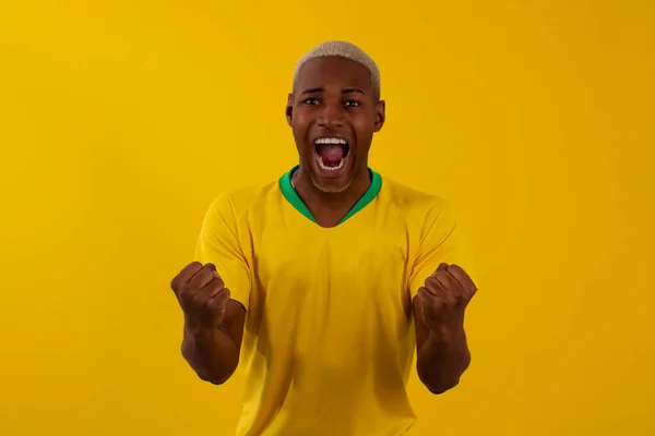 Stüdyo fotoğrafında Brezilya futbol takımı tişörtlü siyah tenli Brezilyalı adam.