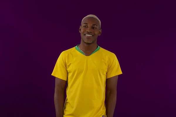 Stüdyo fotoğrafında Brezilya futbol takımı tişörtlü siyah tenli Brezilyalı adam.