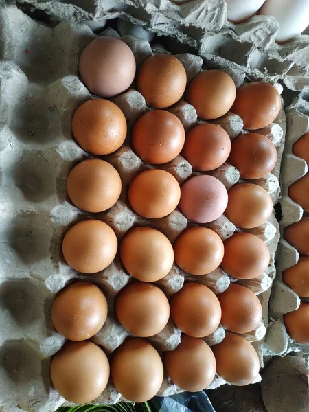 Fresh red chicken eggs are available in traditional markets at varying prices