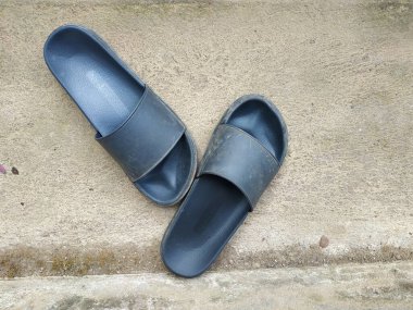 Bir çift kirli siyah terlik Tozlu bir zeminde